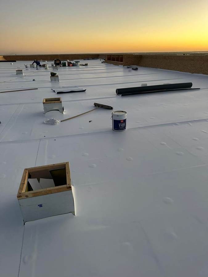 New white TPO membrane on a commercial flat roof at sunrise