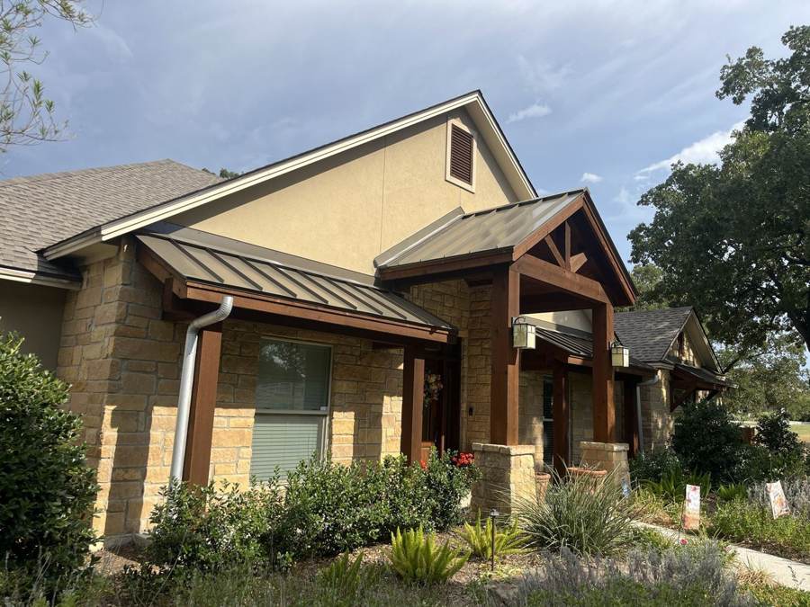 Bronze standing seam porch roofs on a stone home