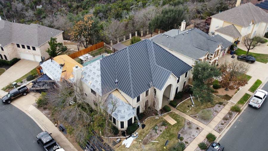 Gray standing seam roof going on over new underlayment