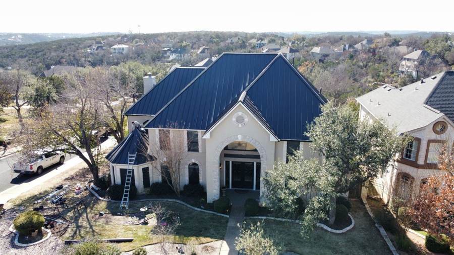 Black standing seam roof being finished on a two-story home