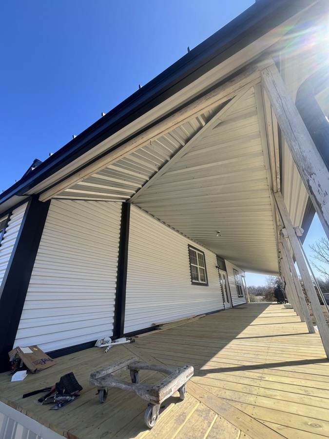 New metal porch ceiling and siding on a farmhouse